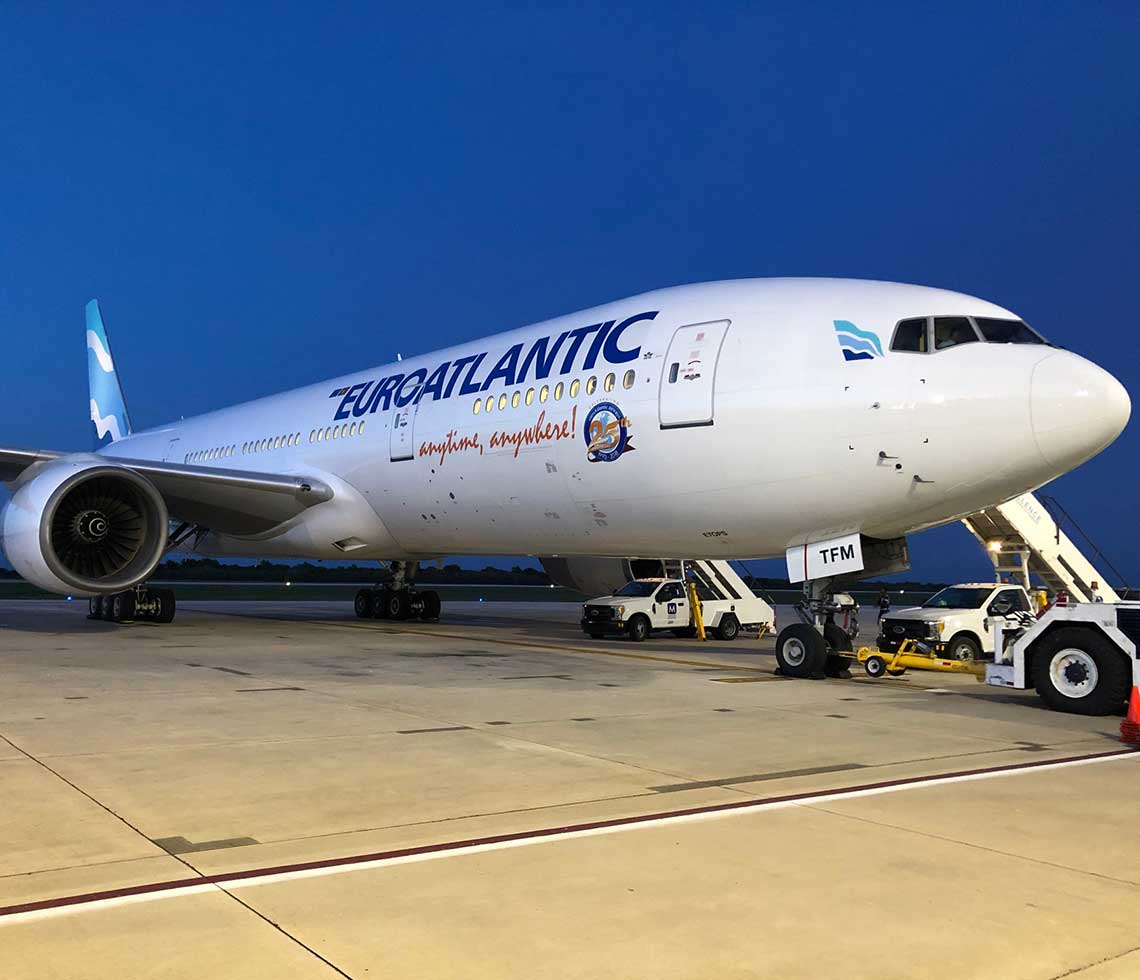 Boeing B777-200 private aircraft charter on runway with boarding ramps