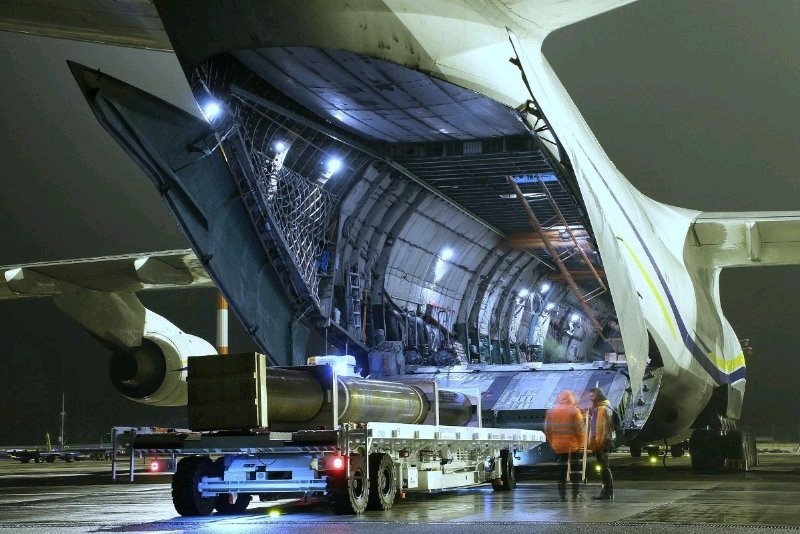 heavy underwater gas pipelinge being loaded onto an aircraft from behind