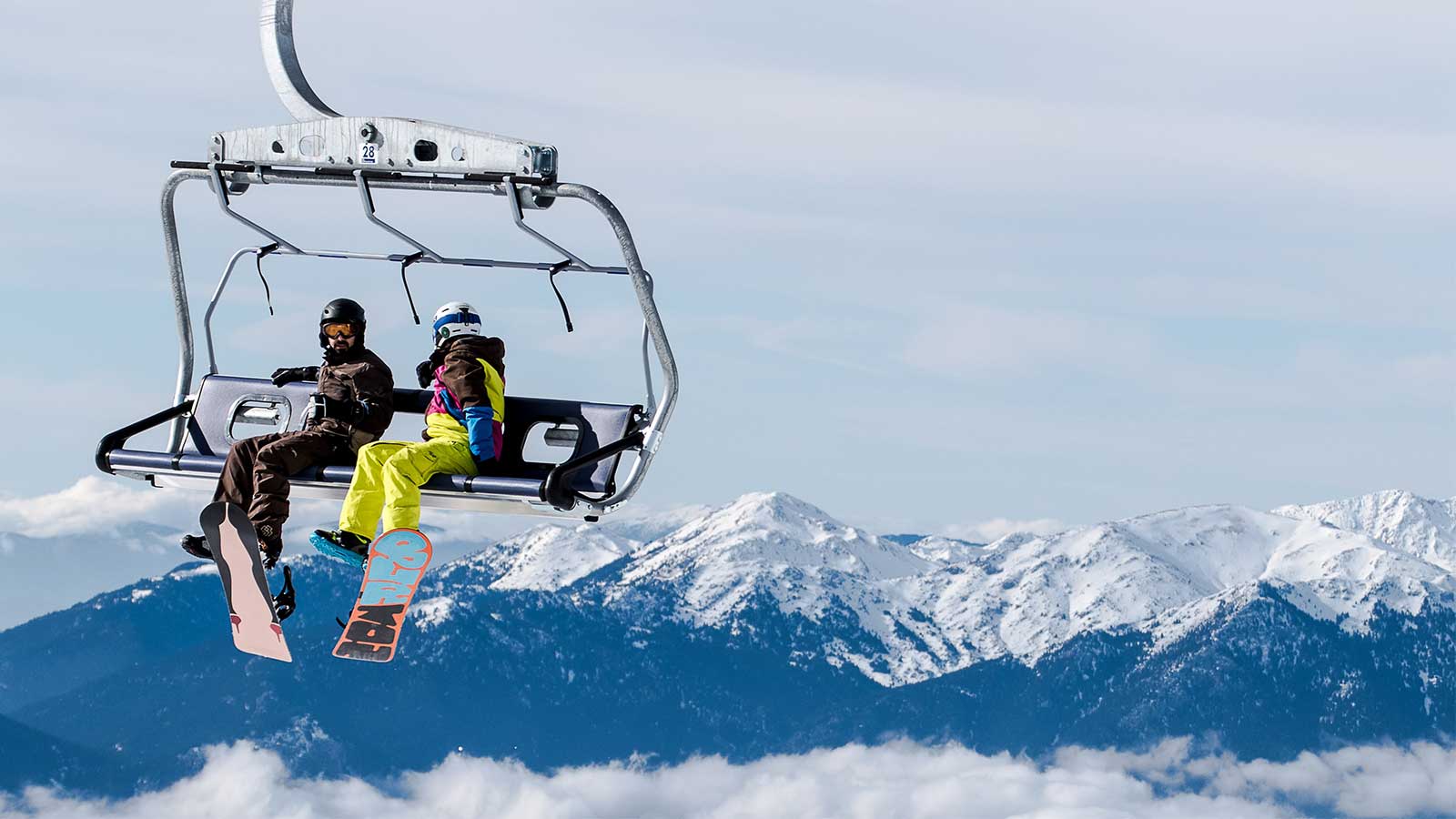 Snowboarders riding ski lift