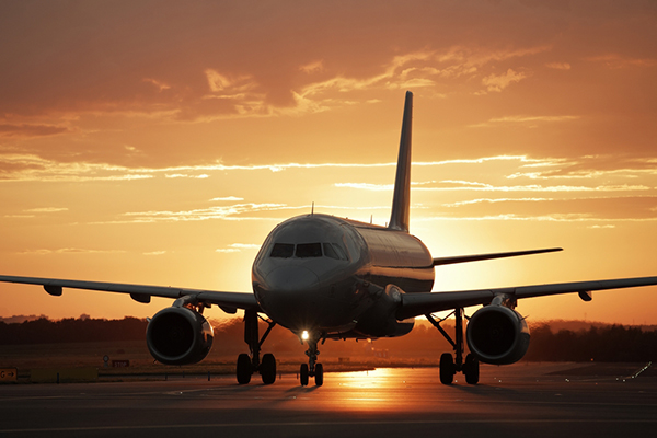 Medium charter aircraft passenger plane on runway at sunset