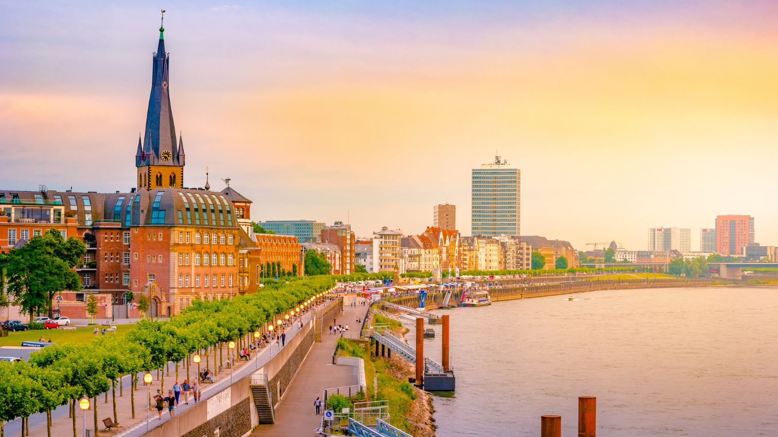 A view at the city skyline central Dusseldorf from the rhine river, Dusselfdorf Germany. Colorful panorama of german city at sunset.